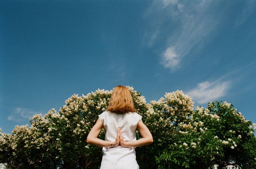 woman with hands behind back meditating for aries season by the astrotwins for astrostyle